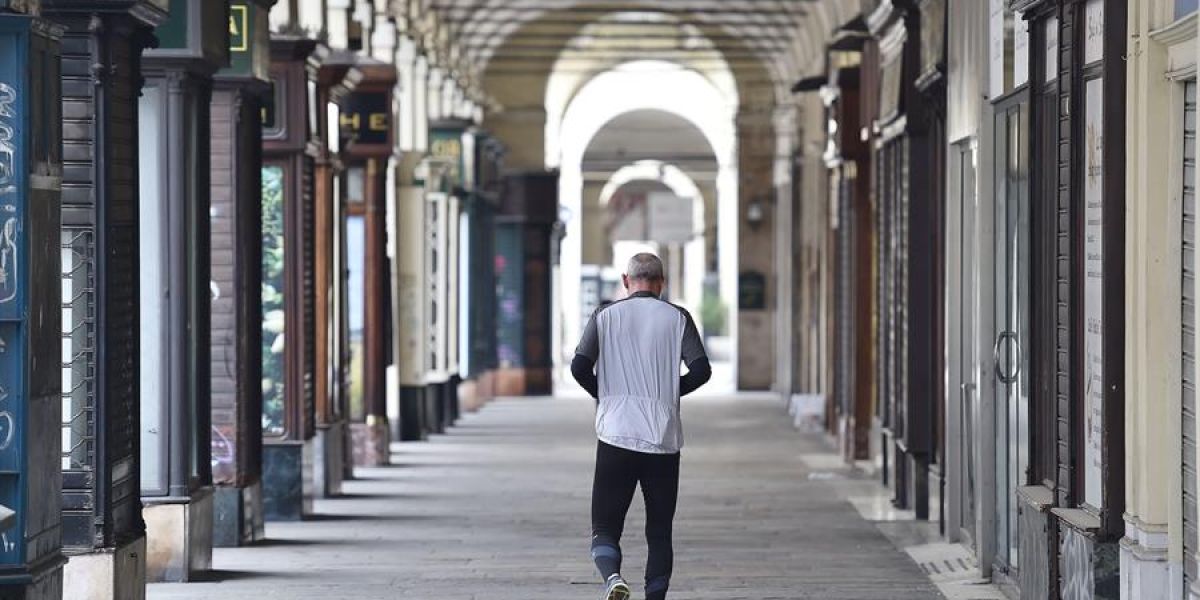 Un hombre camina por una calle vacía de Turín.