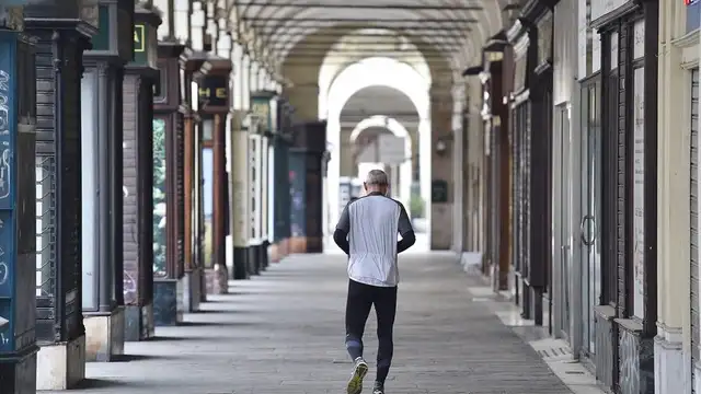 Un hombre camina por una calle vacía de Turín.