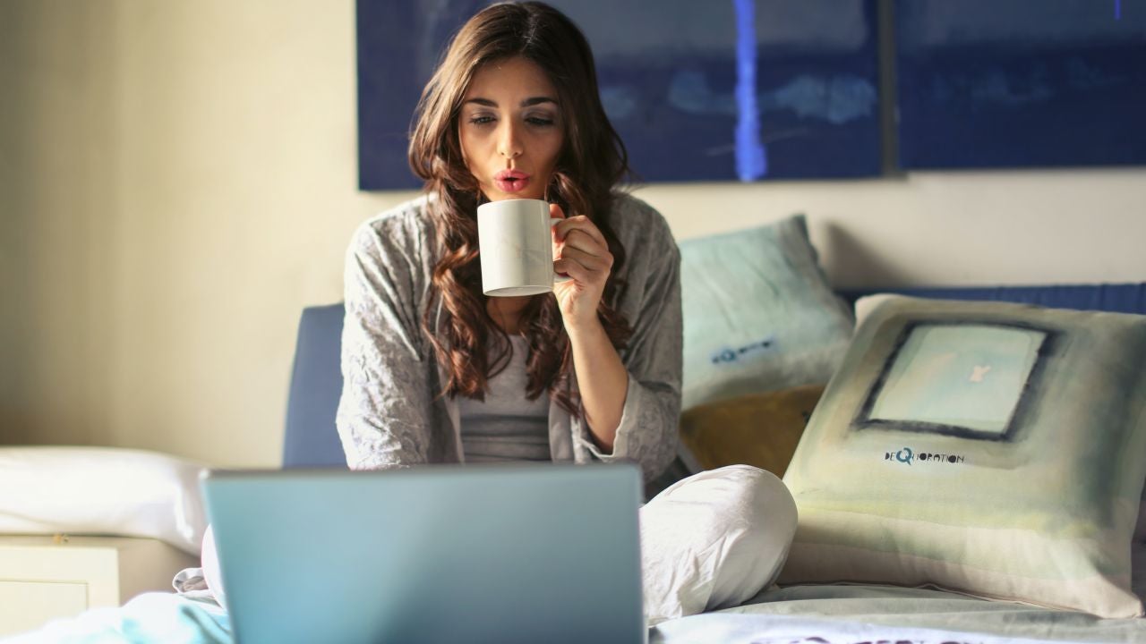 Una chica utilizando su portátil en la cama Una chica utilizando su portátil en la cama