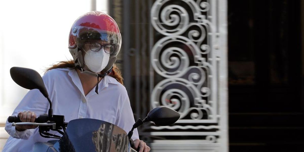 Una motorista con mascarilla