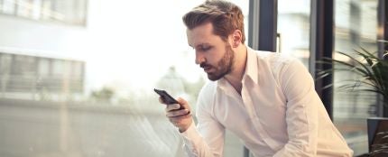 Un hombre mirando su tel&eacute;fono