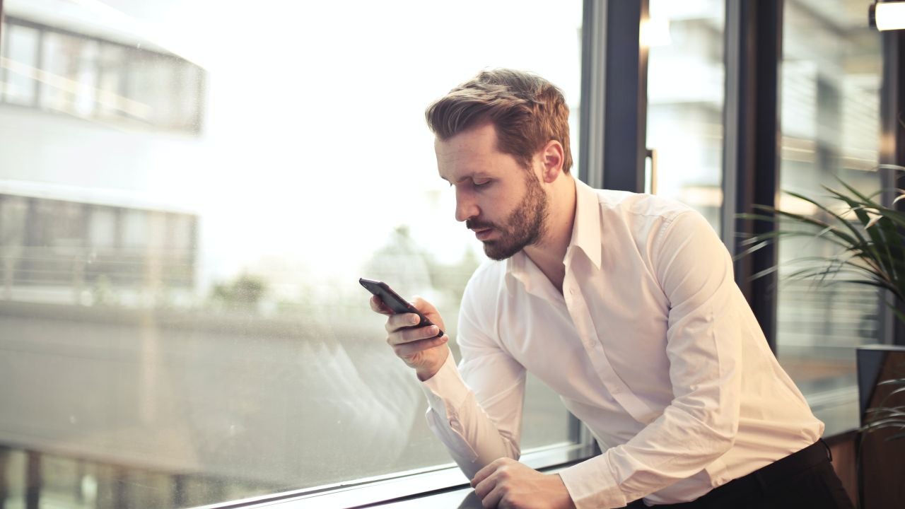 Un hombre mirando su teléfono Un hombre mirando su teléfono