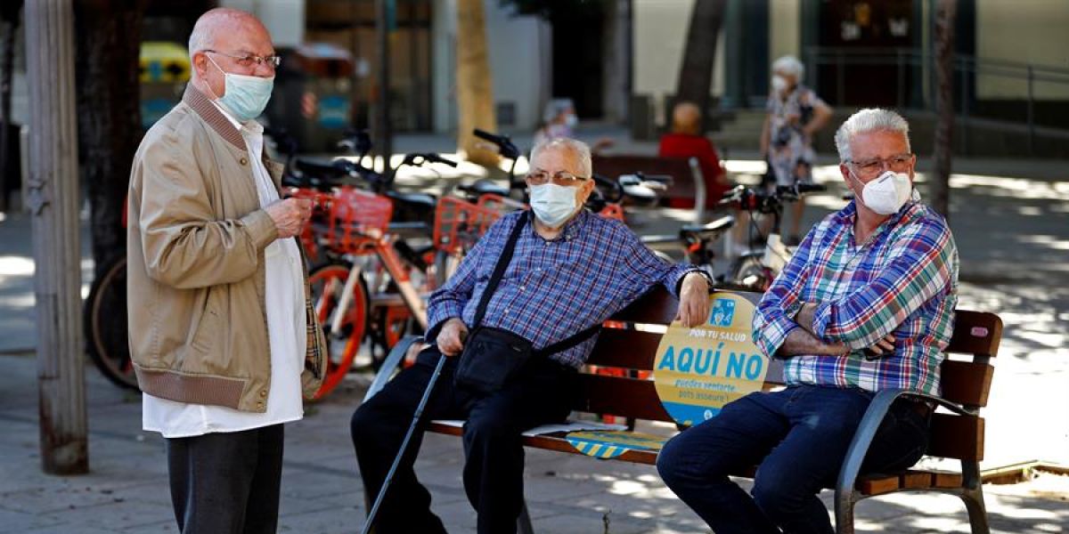 Tres hombres con mascarilla para evitar la propagación del covid-19.