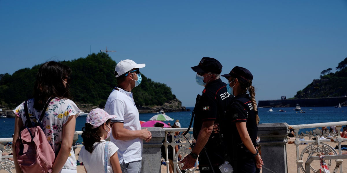 Una familia dialoga con agentes de la Policía en la playa de Ondarreta, en San Sebastián