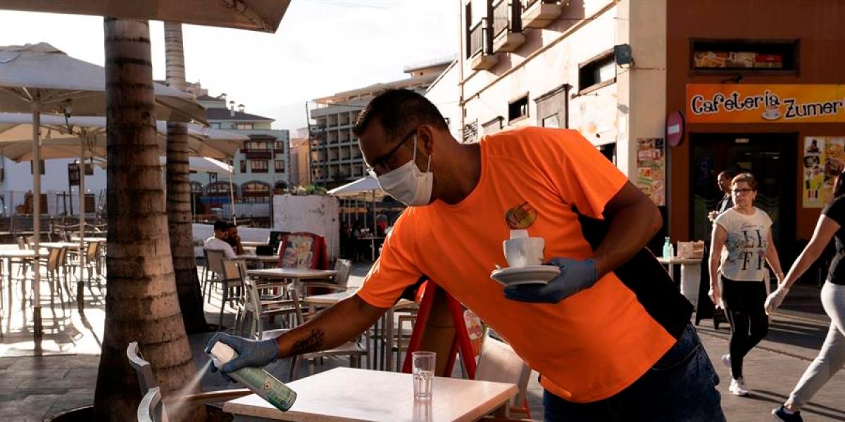 Un camarero desinfecta unas sillas de una terraza de un bar de Puerto de la Cruz, en Tenerife.