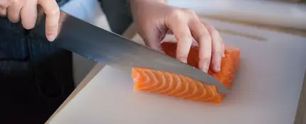 Una persona cortando salmón Una persona cortando salmón