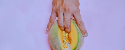 Dedos introduciéndose en un melón Dedos introduciéndose en un melón