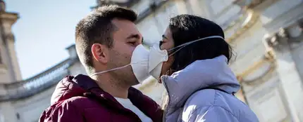 Dos jóvenes besándose con mascarilla Dos jóvenes besándose con mascarilla