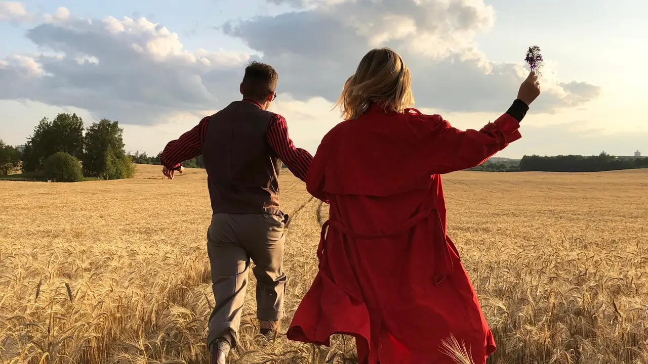 Una pareja corriendo por un campo Una pareja corriendo por un campo