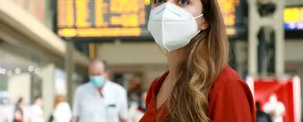 mujer con mascarilla en una estación mujer con mascarilla en una estación