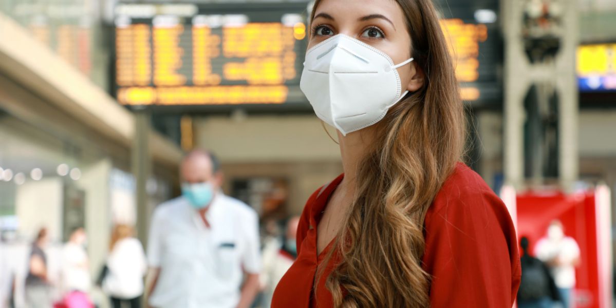 mujer con mascarilla en una estación