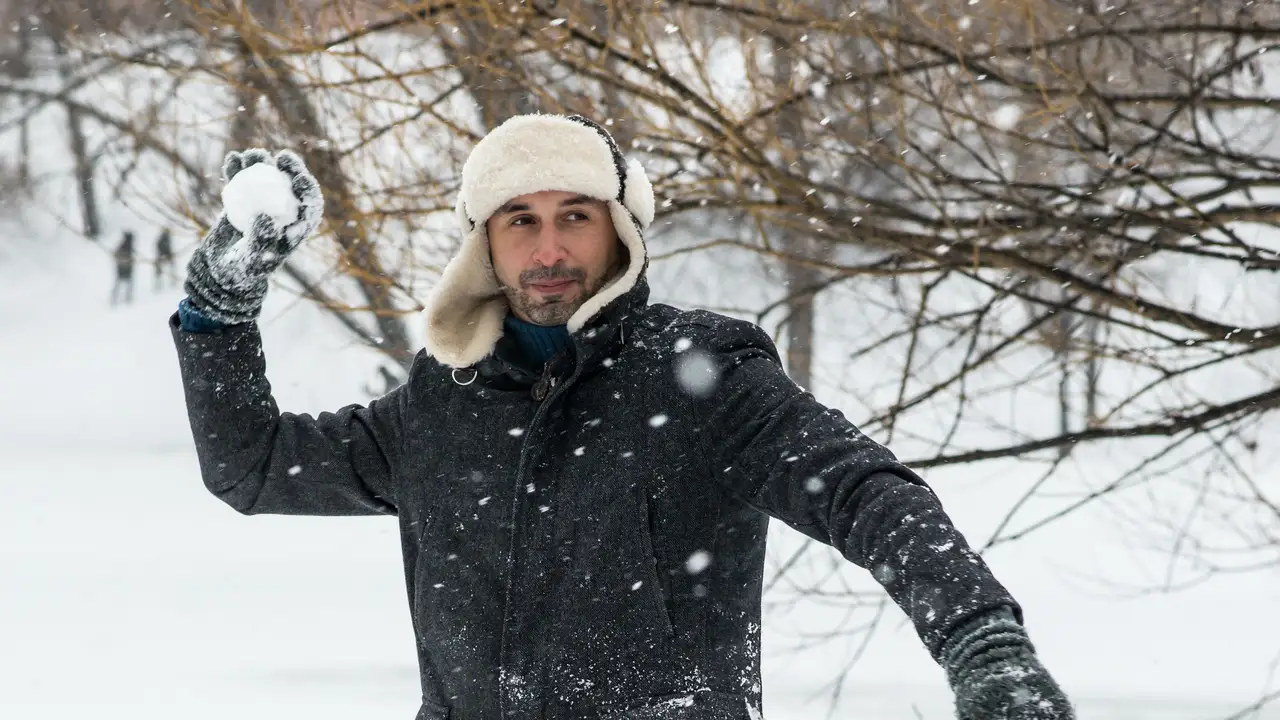 Un hombre lanzando una bola de nieve Un hombre lanzando una bola de nieve