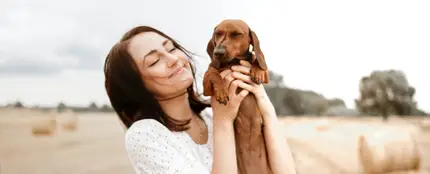 Una chica con su perro en brazos Una chica con su perro en brazos