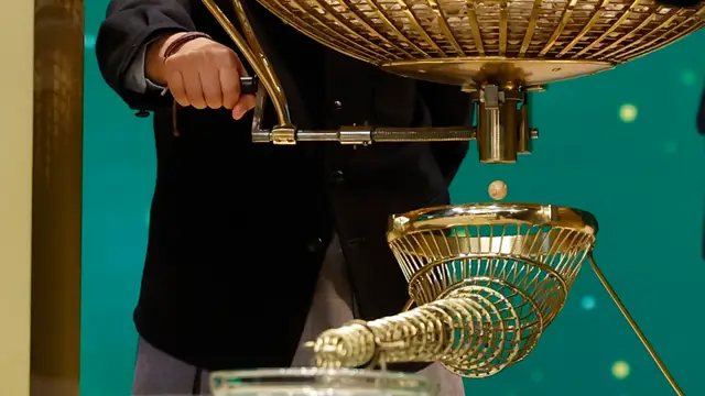 Uno de los niños de San Ildefonso saca las bolas de uno de los bombos durante el sorteo extraordinario de Navidad de la Lotería Nacional este viernes en el Teatro Real de Madrid.